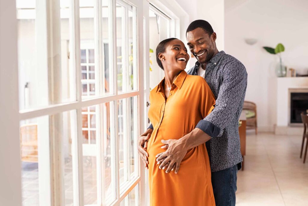 Pregnant black couple embracing