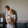 Couple smiling down at their newborn baby