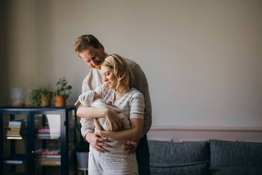 Couple smiling down at their newborn baby
