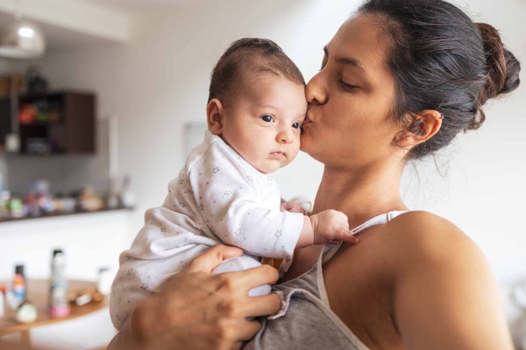 Mother giving a kiss her baby