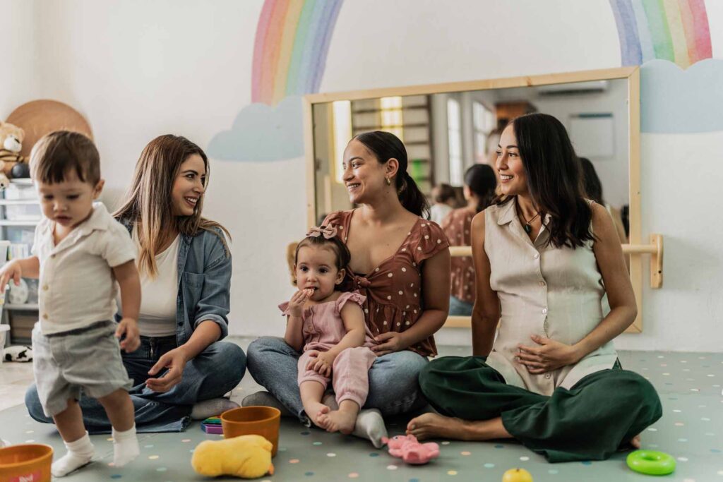 Mothers talking while their toddlers playing