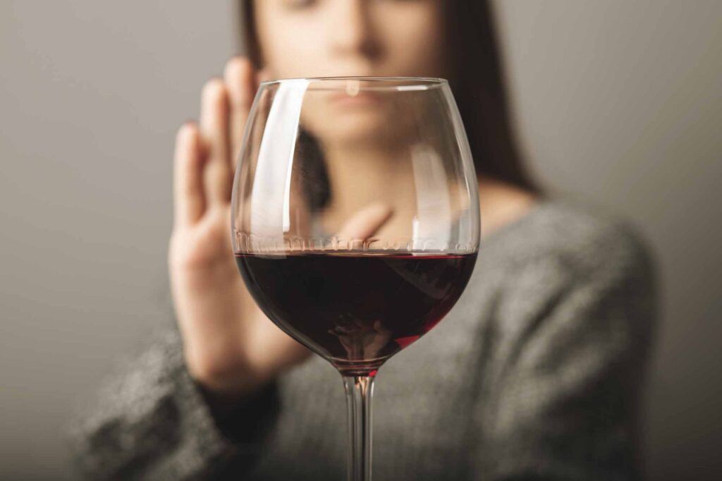 young woman rejects a glass of wine